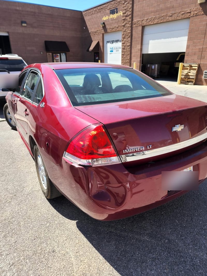 The Impala outside the shop beneath the Evie's Auto Body & Paint and PPG Collision Repair Center signs