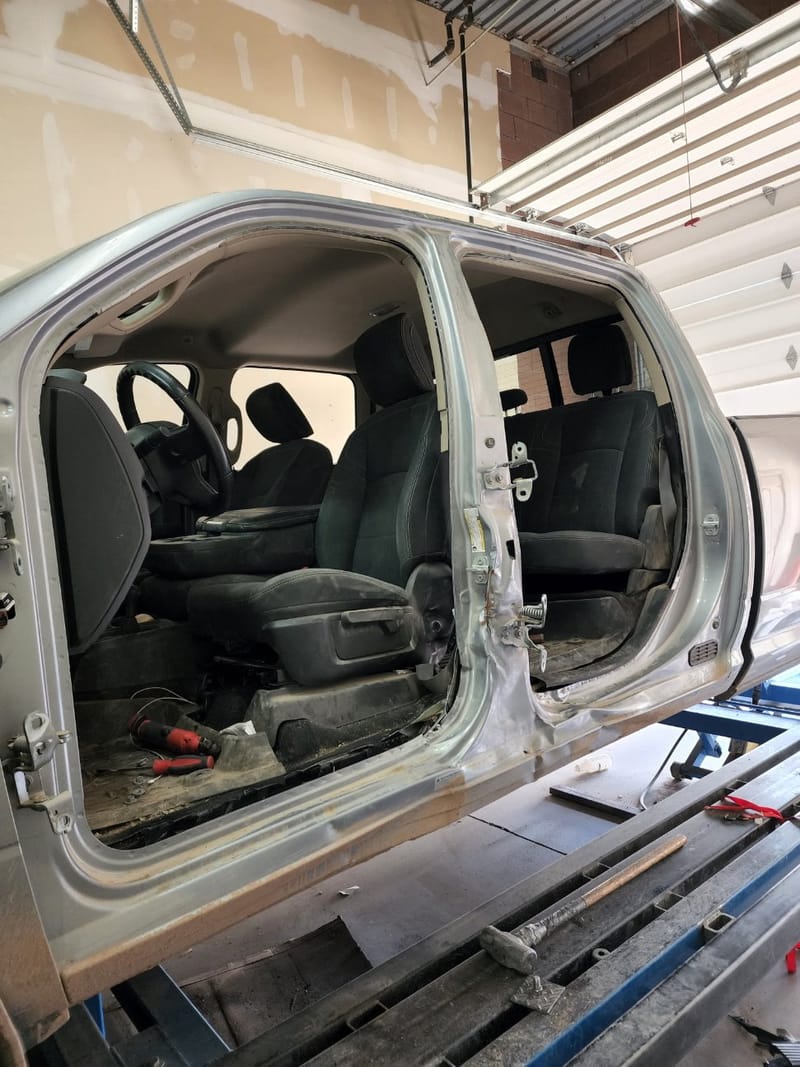 The Ram with both doors removed and the cab interior exposed, still on the rack